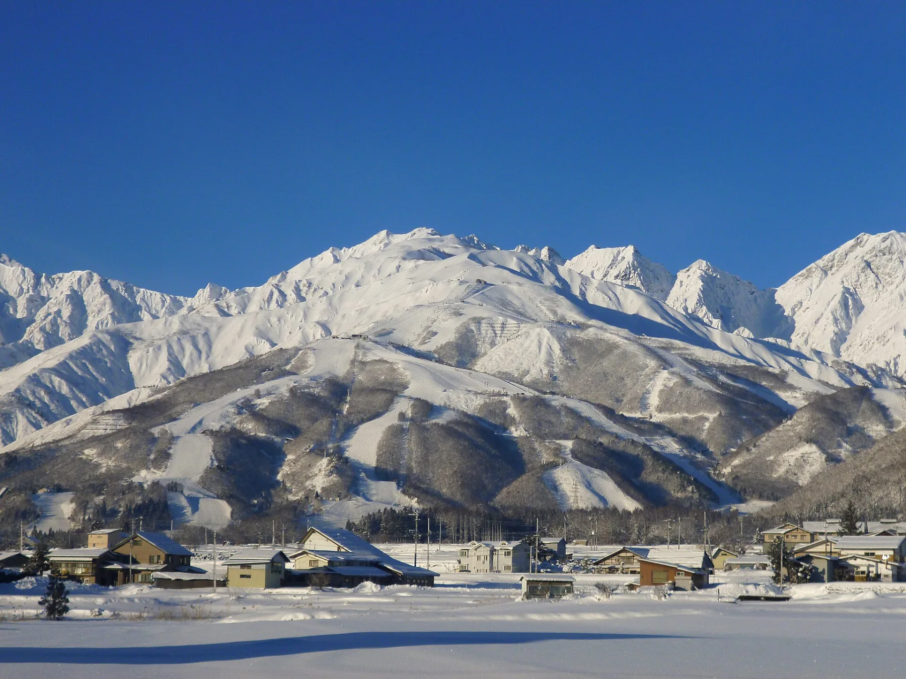 Snow-covered peaks of the Northern Japan Alps above Hakuba Happo-one ski resort in winter