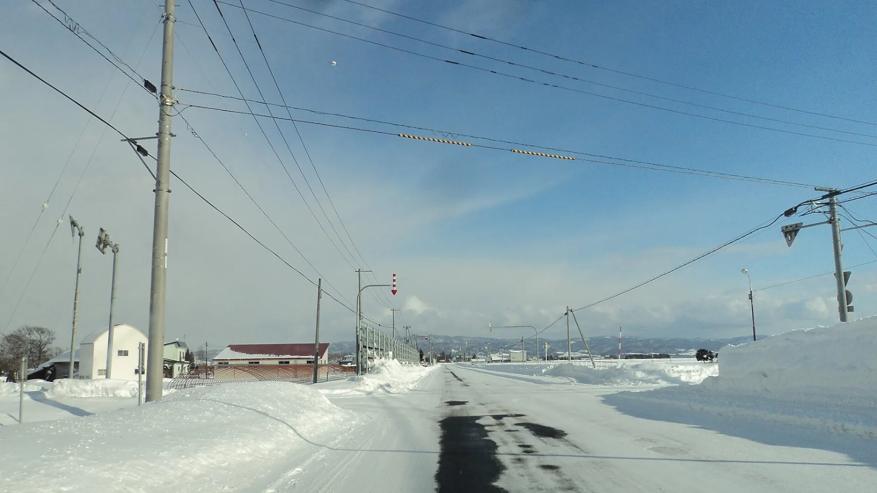 Snowy rural road in Hokkaido with red and white edge markers